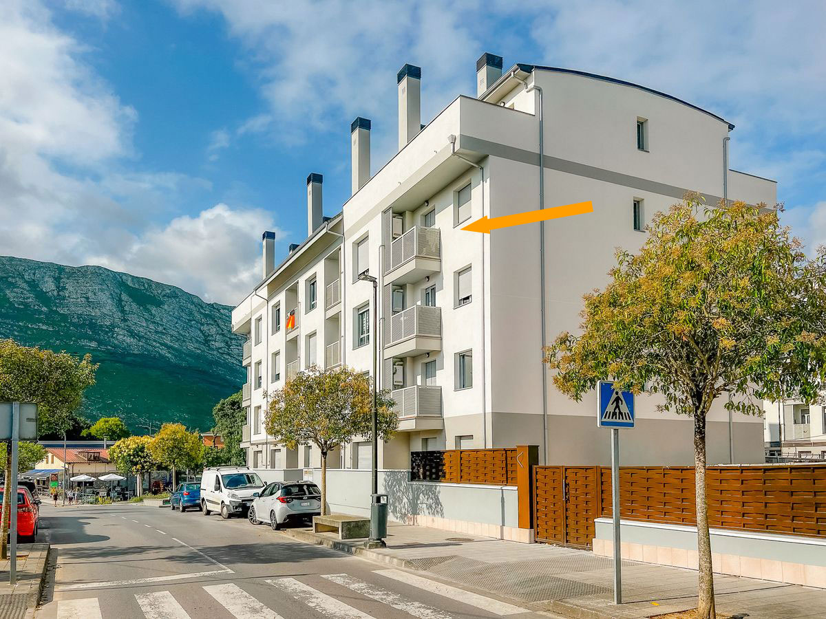 Edificio del apartamento en Posada de Llanes, con una flecha señalando la terraza